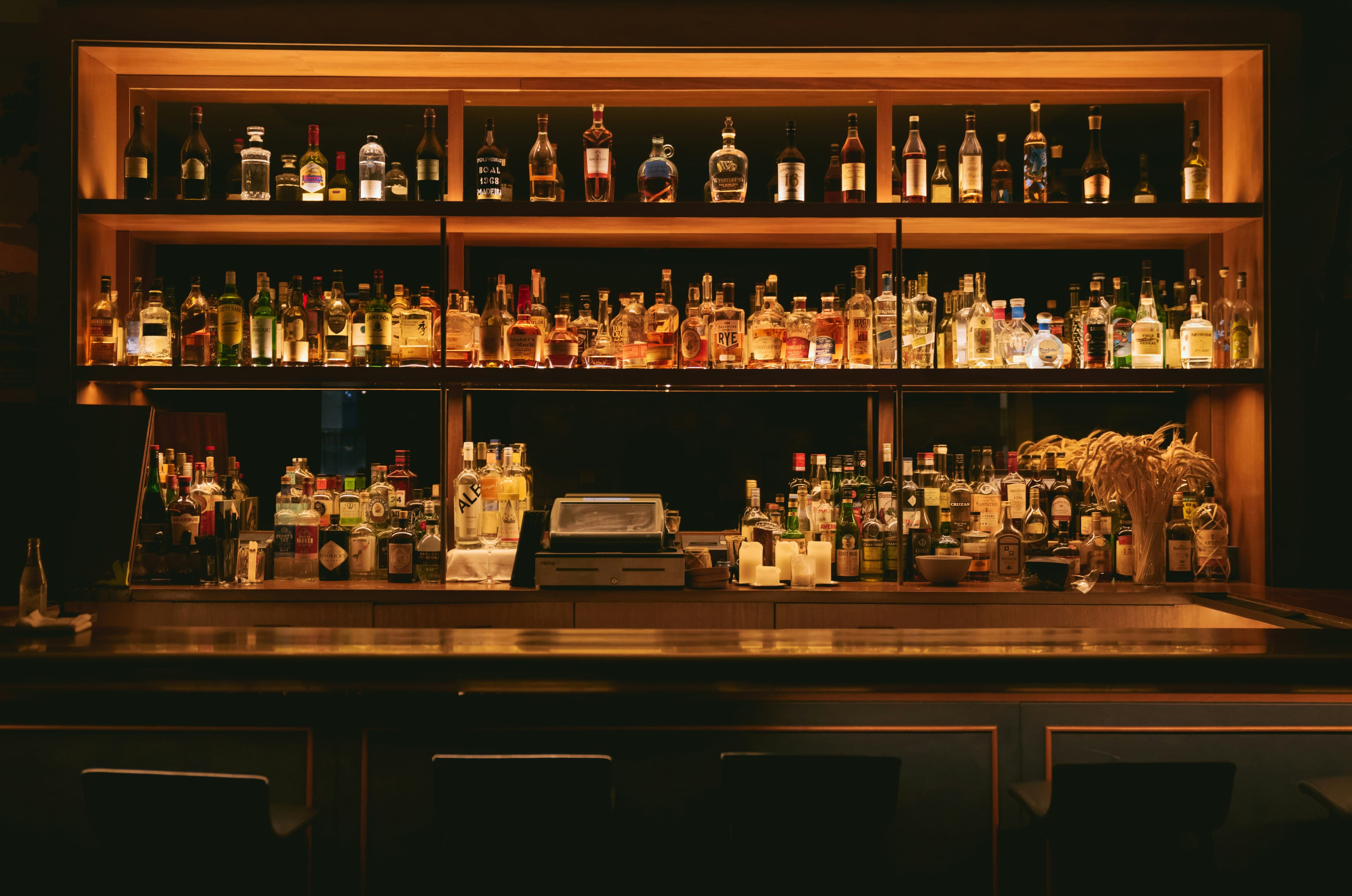 A softly lit back bar lined with bottles